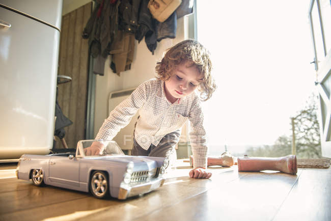 Niño jugando con juguete coche - foto de stock
