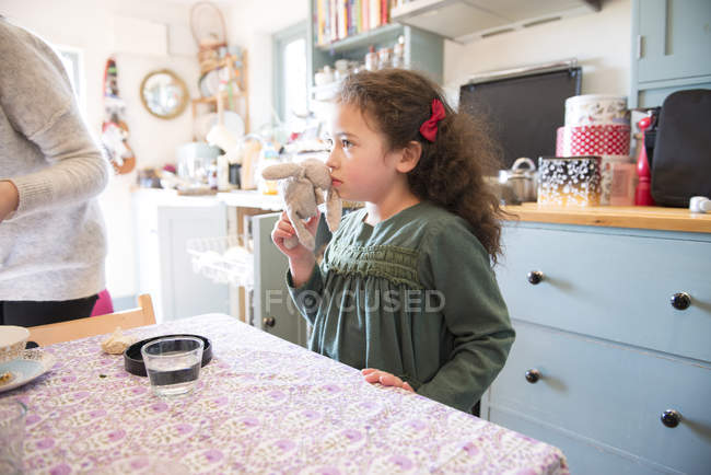 Menina de pé na mesa da cozinha — Fotografia de Stock