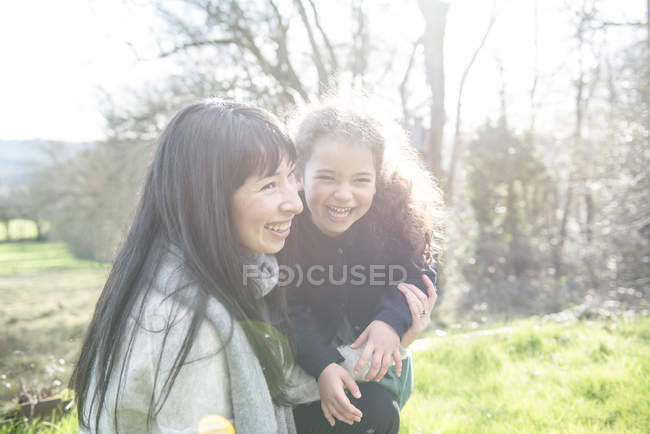 Madre e hija en el jardín de primavera - foto de stock