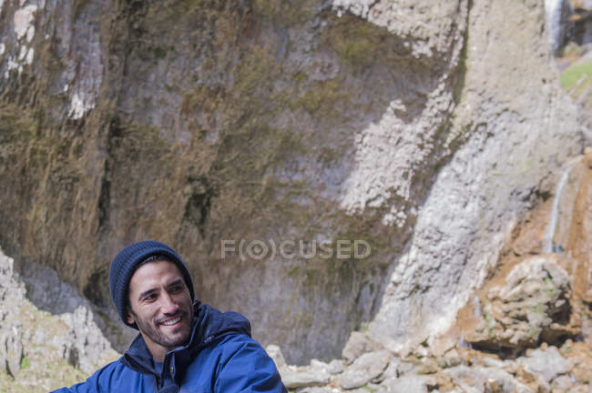 Bergsteiger sitzt in unwegsamem Gelände — Stockfoto