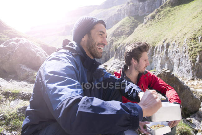 Montañistas sentados y comiendo comida - foto de stock