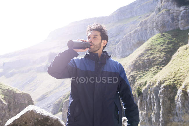 Bergsteiger trinkt Wasser aus Kolben — Stockfoto