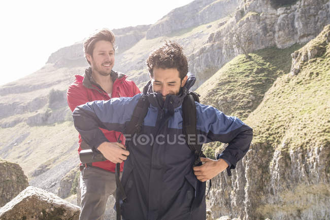 Montanhista ajudando amigo com mochila — Fotografia de Stock