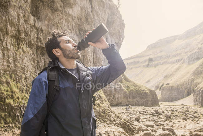 Альпініст п'є з пляшки води — стокове фото