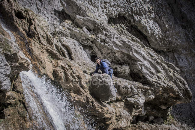 Montañista escalada sobre rocas en terreno accidentado - foto de stock