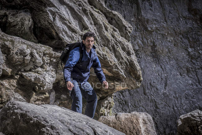 Montanhista em pé sobre rochas em terreno acidentado — Fotografia de Stock