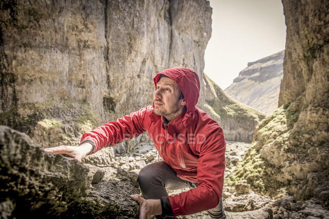 Альпинист карабкается по скалам на пересеченной местности — стоковое фото