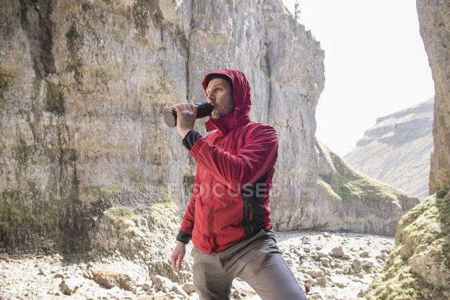 Montañista bebiendo de botella de agua - foto de stock