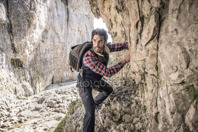 Montañista atravesando repisa rocosa - foto de stock