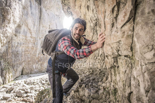 Montañista atravesando repisa rocosa - foto de stock