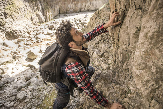 Alpinista che attraversa la sporgenza rocciosa — Foto stock