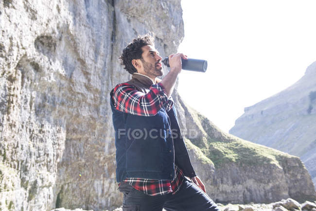 Альпініст п'є з пляшки води — стокове фото