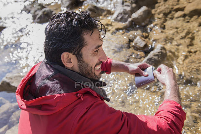 Bergsteiger füllt Wasserflasche — Stockfoto