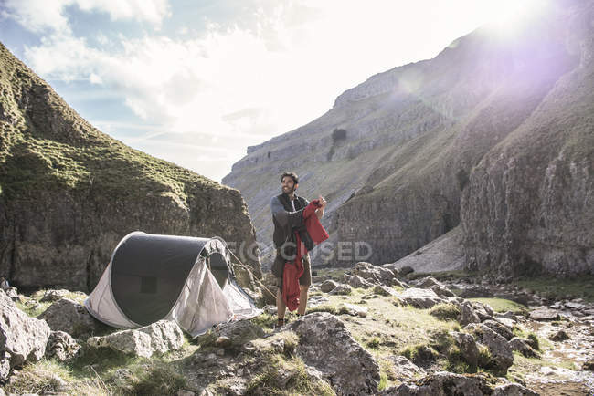 Человек, стоящий у палатки — стоковое фото