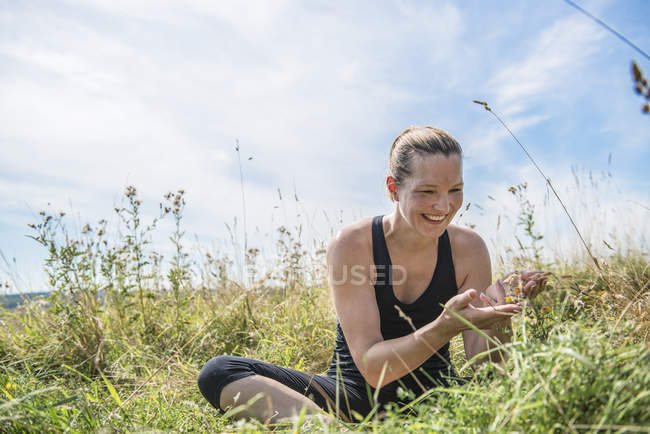 Женщина на лугу, практикующая йогу — стоковое фото