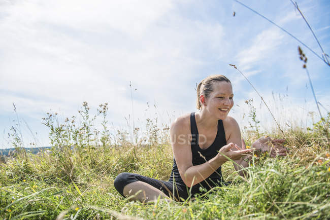 Woman in meadow practicing yoga — Stock Photo