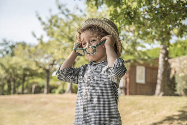 Boy putting on sunglasses — Stock Photo