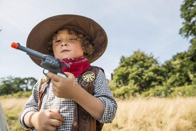 Junge spielt Cowboys und Indianer draußen — Stockfoto