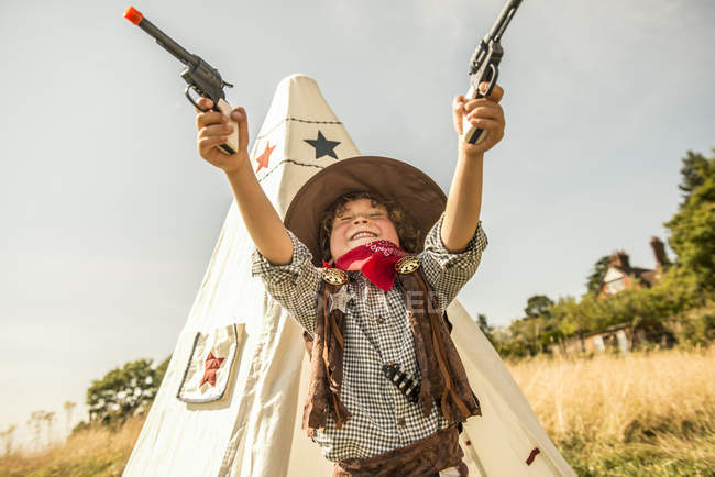 Menino joga cowboys e índios fora — Fotografia de Stock
