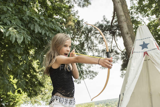 Young girl shoots bow — Stock Photo