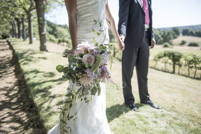 Braut und Bräutigam mit Blumenstrauß — Stockfoto