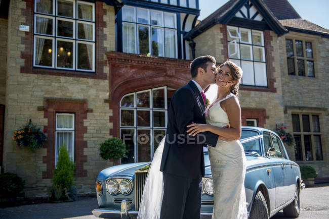 Braut und Bräutigam teilen Kuss am Hochzeitstag — Stockfoto