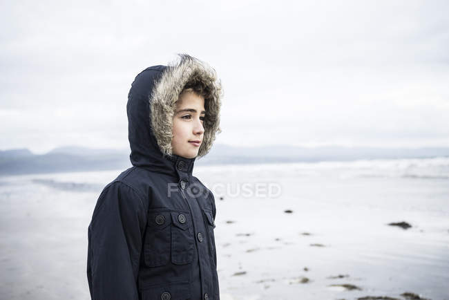 Menino em pé na praia — Fotografia de Stock