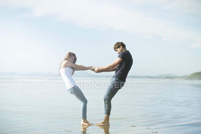 Couple holding hands on beach — Stock Photo