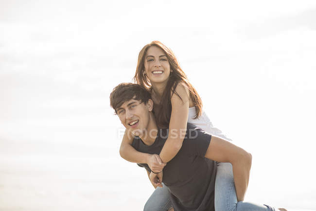 Man giving piggyback ride to female friend — Stock Photo