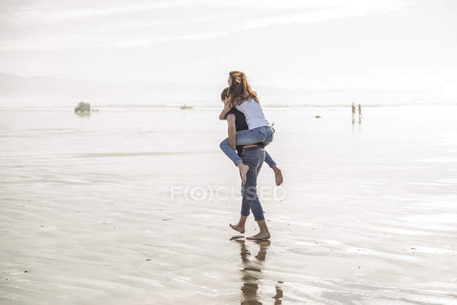 Mann gibt Huckepack-Fahrt zu Freundin — Stockfoto