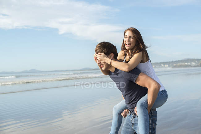 Homem dando passeio de piggyback para amigo feminino — Fotografia de Stock