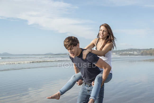 Uomo dando cavalcata a cavalluccio di amico femminile — Foto stock