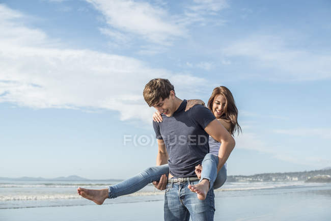 Hombre dando paseo a cuestas a una amiga - foto de stock