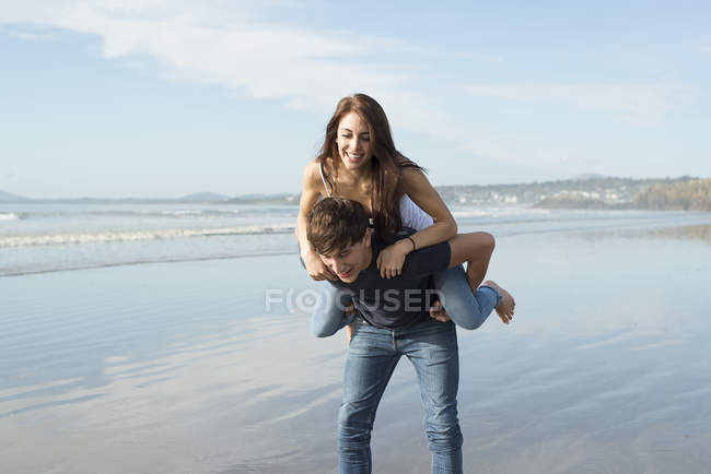 Homme donnant piggyback tour à un ami féminin — Photo de stock