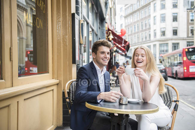 Friends sitting outside cafe — Stock Photo