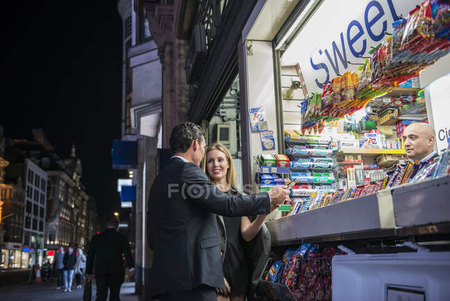 Couple achetant des confiseries au kiosque — Photo de stock