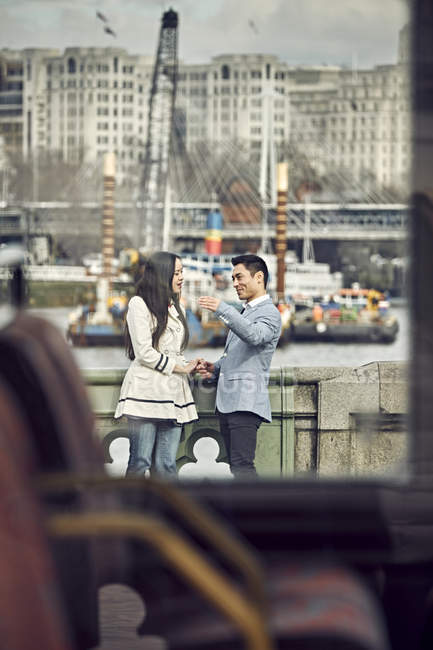 Paar unterhält sich auf Brücke — Stockfoto
