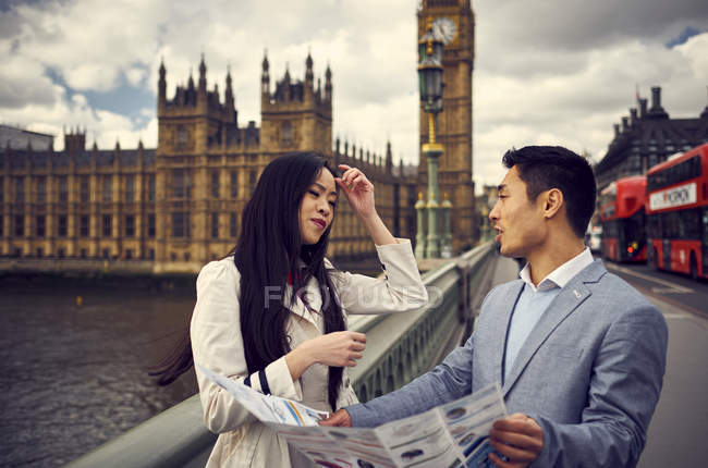Couple discutant tout en regardant la carte de voyage — Photo de stock