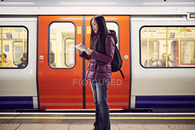 Японская женщина стоит на станции метро — стоковое фото