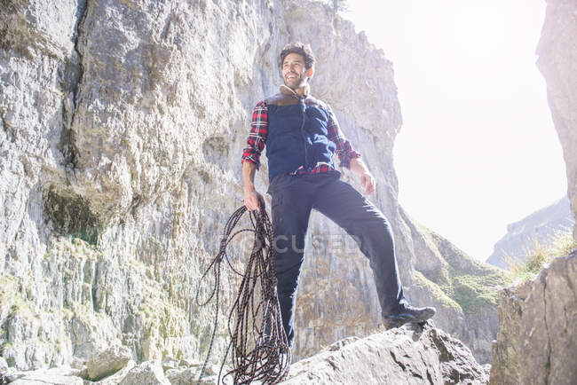 Альпинист, стоящий с веревкой — стоковое фото