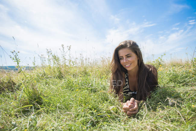 Femme bénéficie d'une journée ensoleillée dans la prairie — Photo de stock