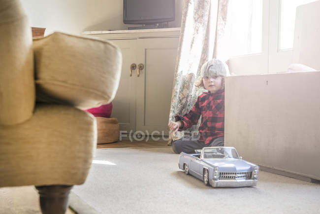 Boy playing with toy car. — Stock Photo
