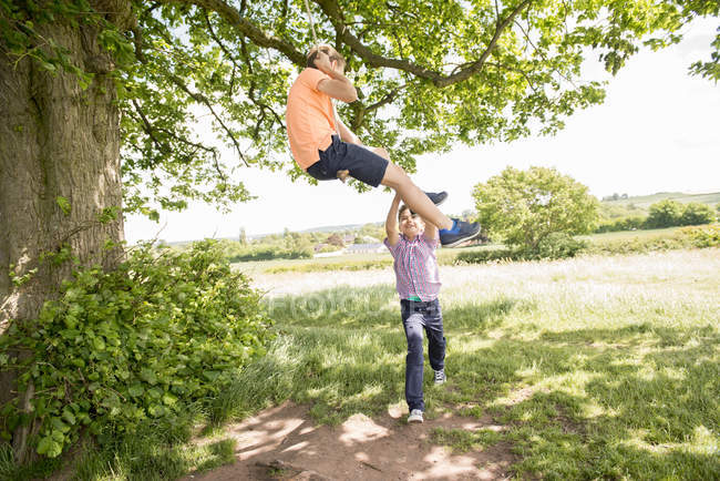 Jungen spielen auf Schaukel im Grünen — Stockfoto