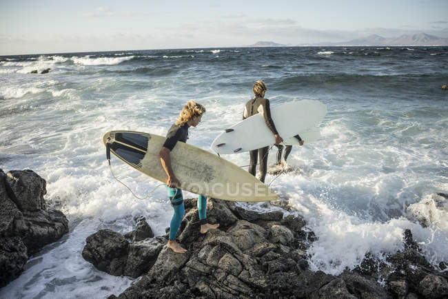 Homens em um terno molhado se preparando para surfar — Fotografia de Stock