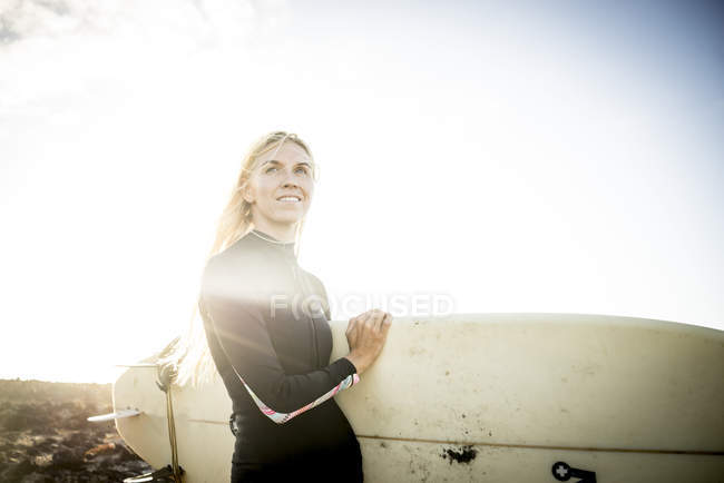 Жінка в мокрій костюмі готується до серфінгу — стокове фото