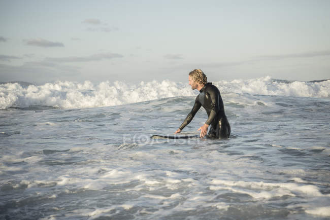 Homem de fato de mergulho a preparar-se para surfar — Fotografia de Stock
