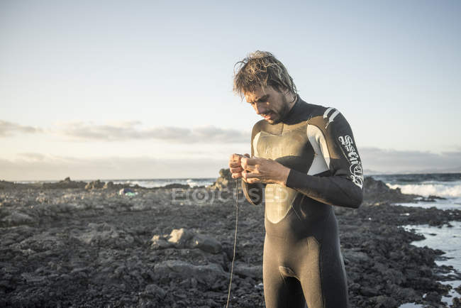 Homem em um terno molhado se preparando para surfar — Fotografia de Stock