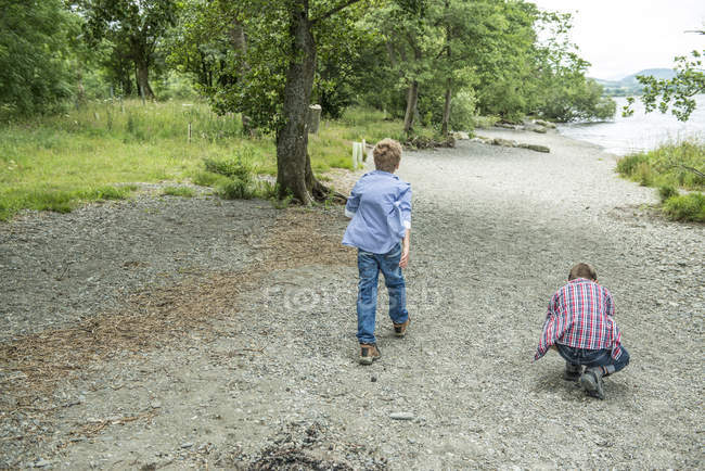 Chicos jugando en la orilla - foto de stock