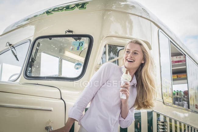 Chica de pie delante de la furgoneta de helado - foto de stock