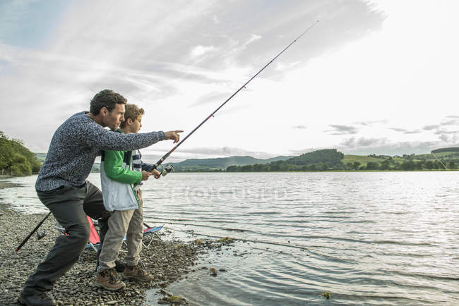 Father and son fishing from shore — Stock Photo